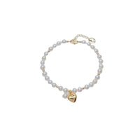Freshwater Pearl Bracelet featuring lustrous white pearls with small gold beads and a gold plated heart charm centerpiece.