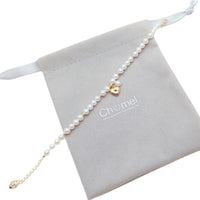 Freshwater Pearl Bracelet featuring white freshwater pearls and gold beads with a gold heart and pearl charm centerpiece