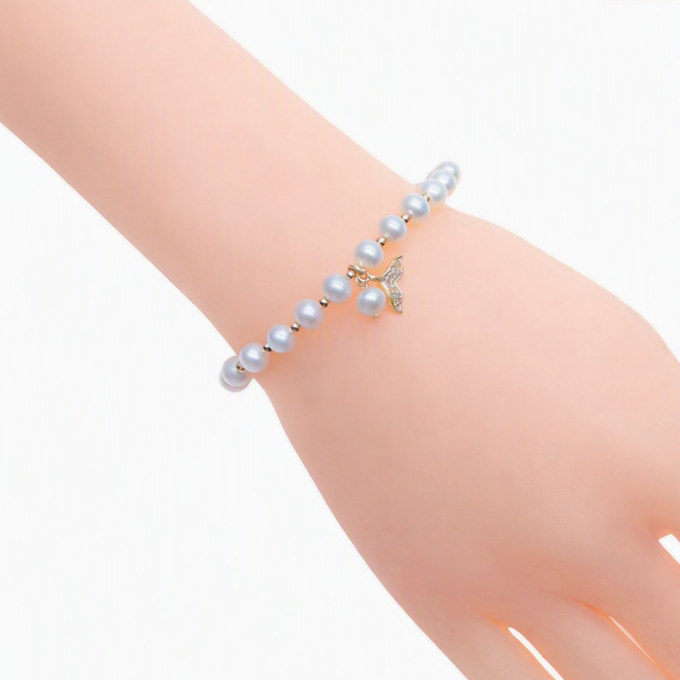 Freshwater Pearl Bracelet with lustrous light grey freshwater pearls, gold beads, and a gold mermaid's tail charm centerpiece.