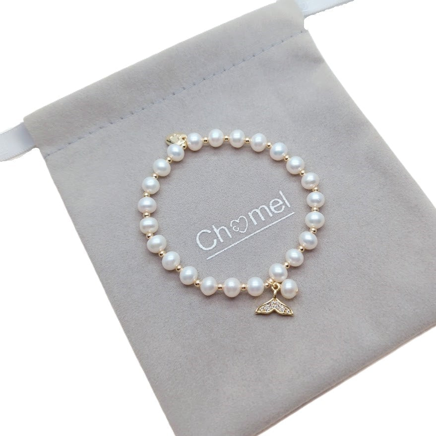 Freshwater Pearl Bracelet with lustrous white pearls, alternating gold beads, and a gold mermaid's tail charm on elastic band