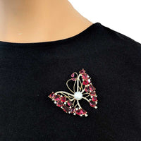 Gold-plated butterfly brooch with cubic zirconia, red stones, and freshwater pearl mother of pearl detail