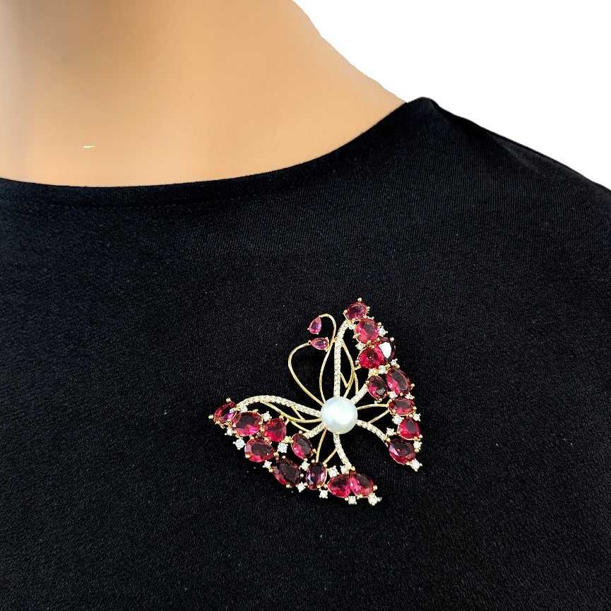 Gold-plated butterfly brooch with cubic zirconia, red stones, and freshwater pearl mother of pearl detail