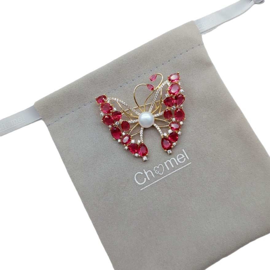 Gold-plated butterfly brooch with cubic zirconia, red stones, and freshwater pearls, butterfly mother of pearl design