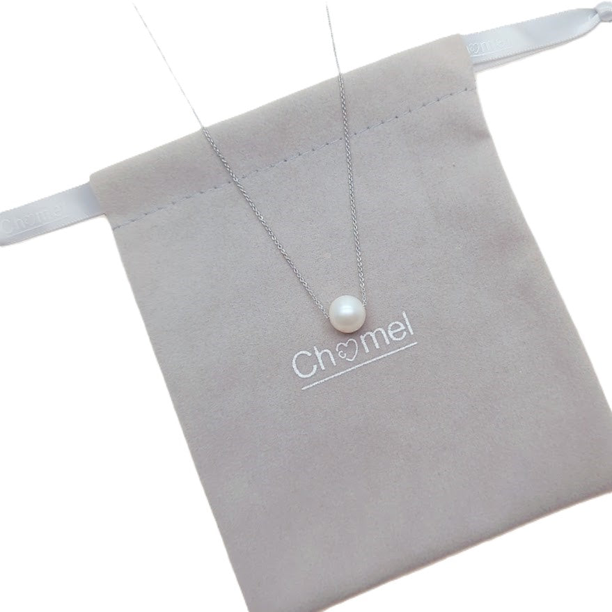 Freshwater Pearl Necklace with a single white pearl on a delicate rhodium plated chain resting on a grey pouch