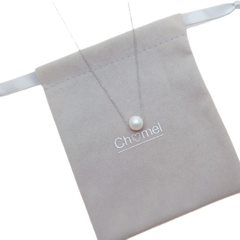 Freshwater Pearl Necklace with a single white pearl on a delicate rhodium plated chain resting on a grey pouch