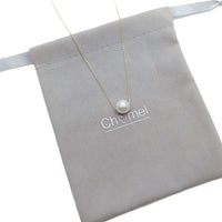 Freshwater Pearl Necklace with a single white pearl on a delicate gold-plated chain displayed on a soft grey pouch.