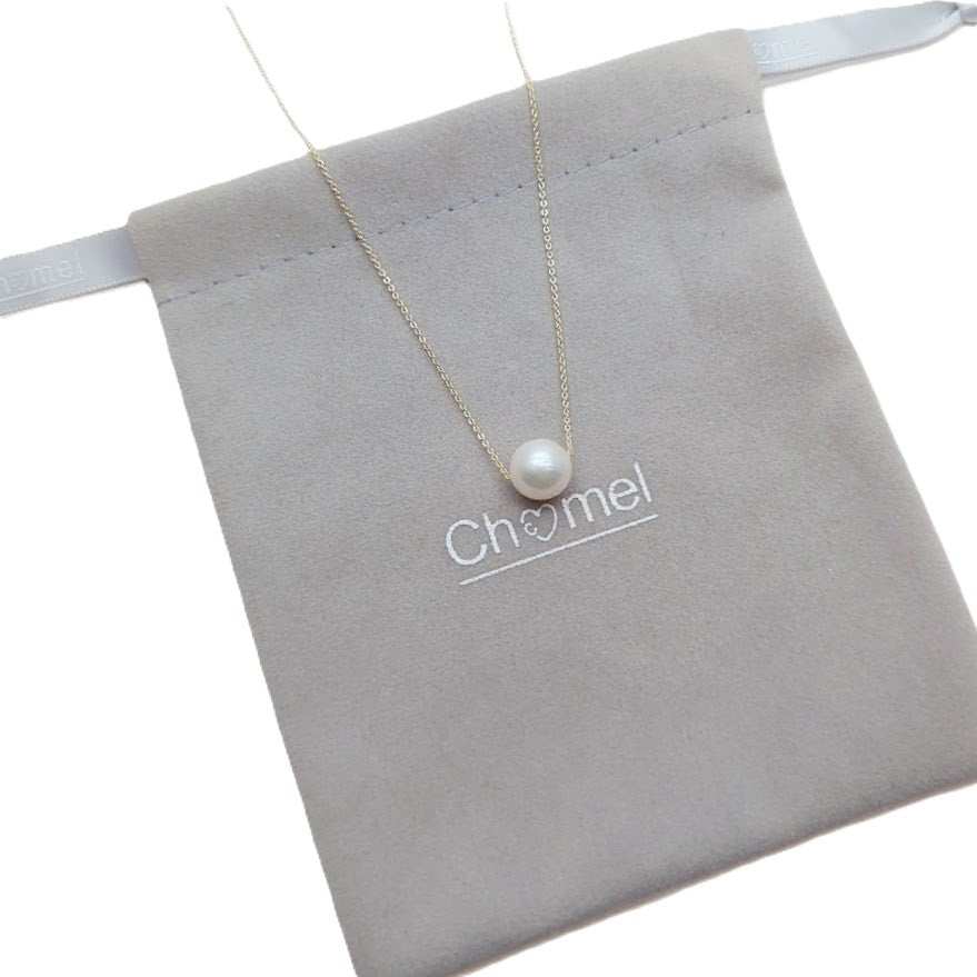 Freshwater Pearl Necklace with a single white pearl on a delicate gold-plated chain displayed on a soft grey pouch.