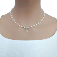 Freshwater Pearl Necklace with 4-5mm roundish pearls, gold-plated beads, and a small gold pendant on a wire choker.
