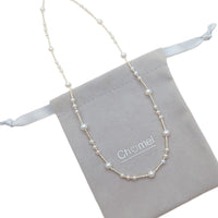 Freshwater Pearl Necklace featuring irregular round white pearls strung on delicate gold-plated filigree wire with adjustable clasp