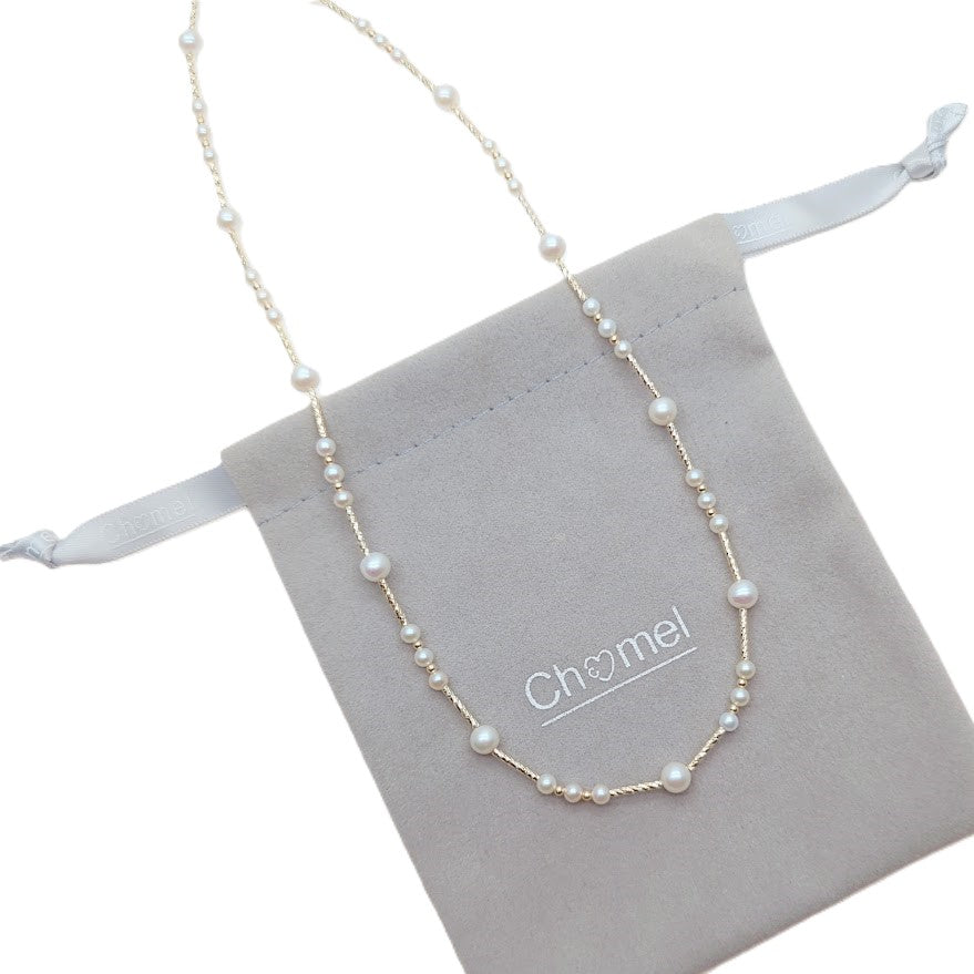 Freshwater Pearl Necklace featuring irregular round white pearls strung on delicate gold-plated filigree wire with adjustable clasp