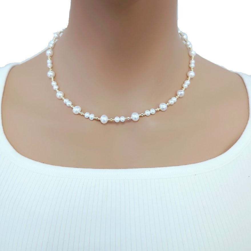 Freshwater Pearl Necklace with 4 and 6mm roundish potato-shaped white pearls alternating with small gold-plated beads on a delicate wire choker.