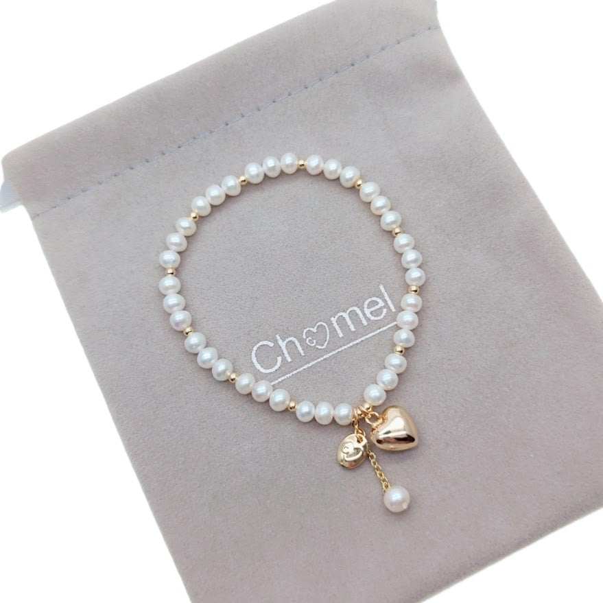 Freshwater pearl bracelet with alternating gold beads and gold heart charm on elastic band
