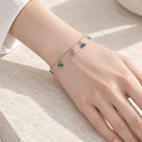 Cubic zirconia tennis bracelet with dangling colorful cherry charms and rhodium plated finish
