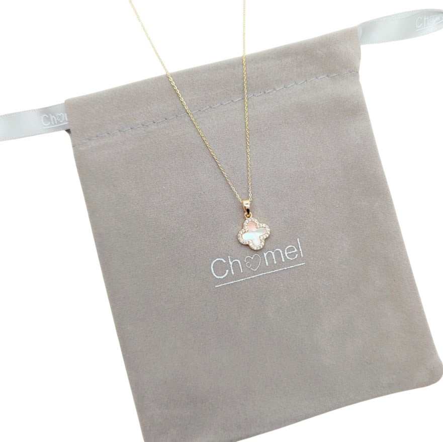 clover necklace with a gold-tone chain and a small white clover pendant edged in sparkling stones