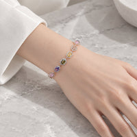Cubic Zirconia Tennis Bracelet with colourful pastel stones framed in hexagonal rosegold plated settings on wrist.