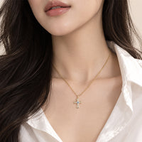Cubic zirconia cross pendant necklace in gold plated finish with sparkling stones, complementing an elegant Interlocking Ring style.