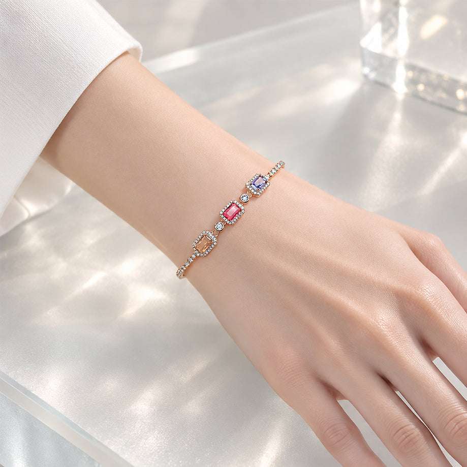 Adjustable cz bracelet in gold-tone metal with three colourful rectangular stones, each bordered by small clear stones.