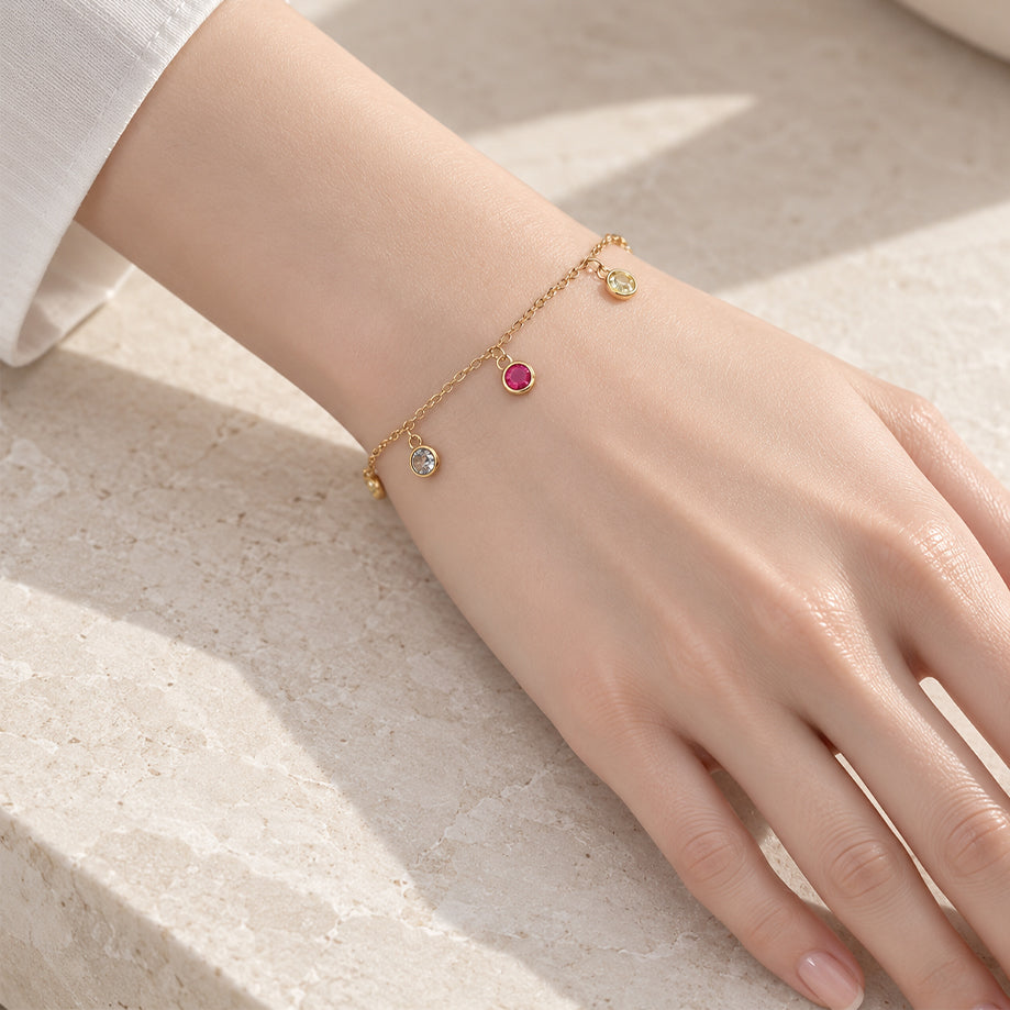 Colorful cubic zirconia tennis bracelet with gold-plated rims on adjustable chain