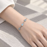cz bracelet with a delicate silver-tone chain, featuring sparkling blue heart-shaped stones and small crystal accents