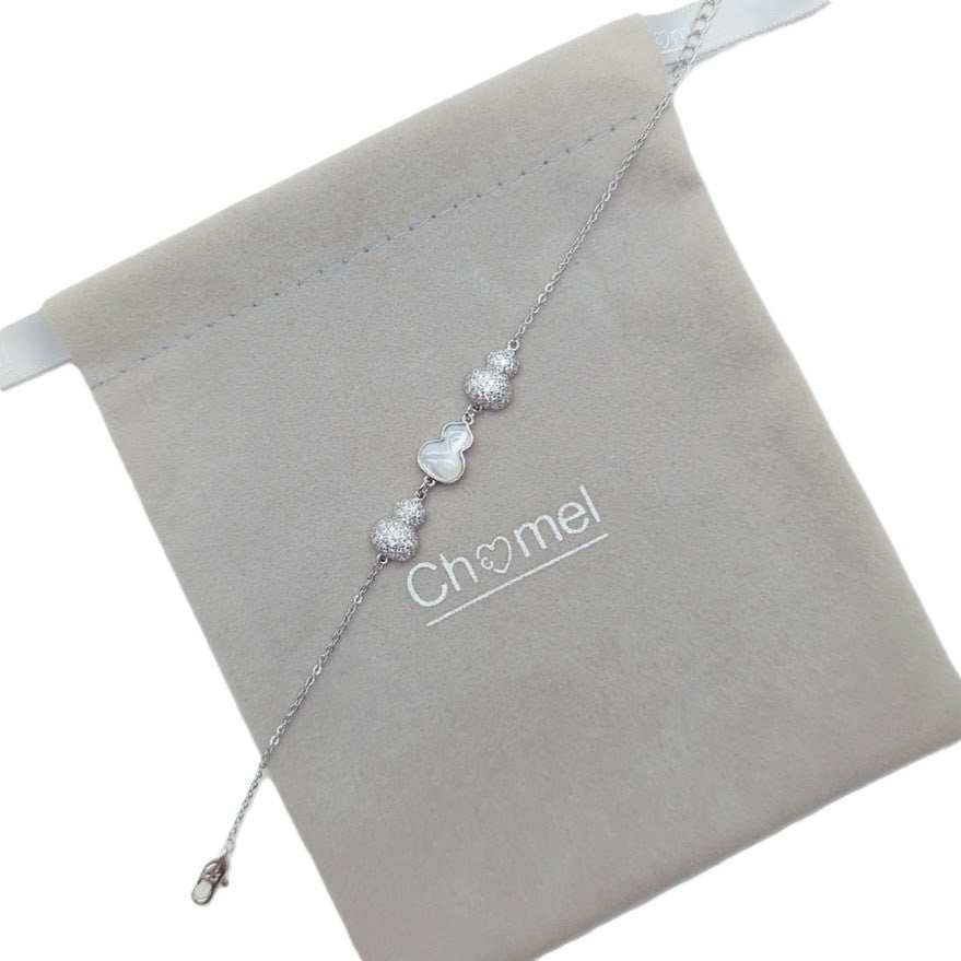 Silver-tone cz bracelet with a delicate chain, sparkling cubic zirconia beads and a white mother-of-pearl gourd charm.