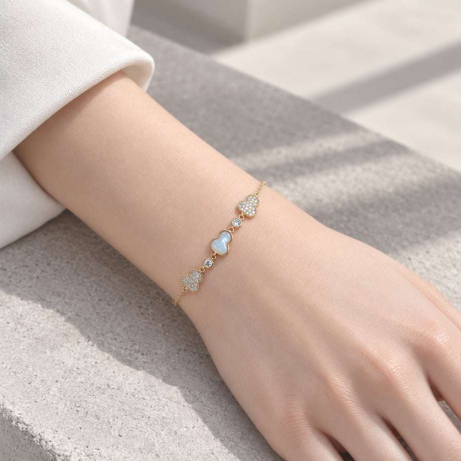 Gold-toned cz bracelet with a delicate chain, sparkling clear stones, and pale blue and white gourd-shaped charms.