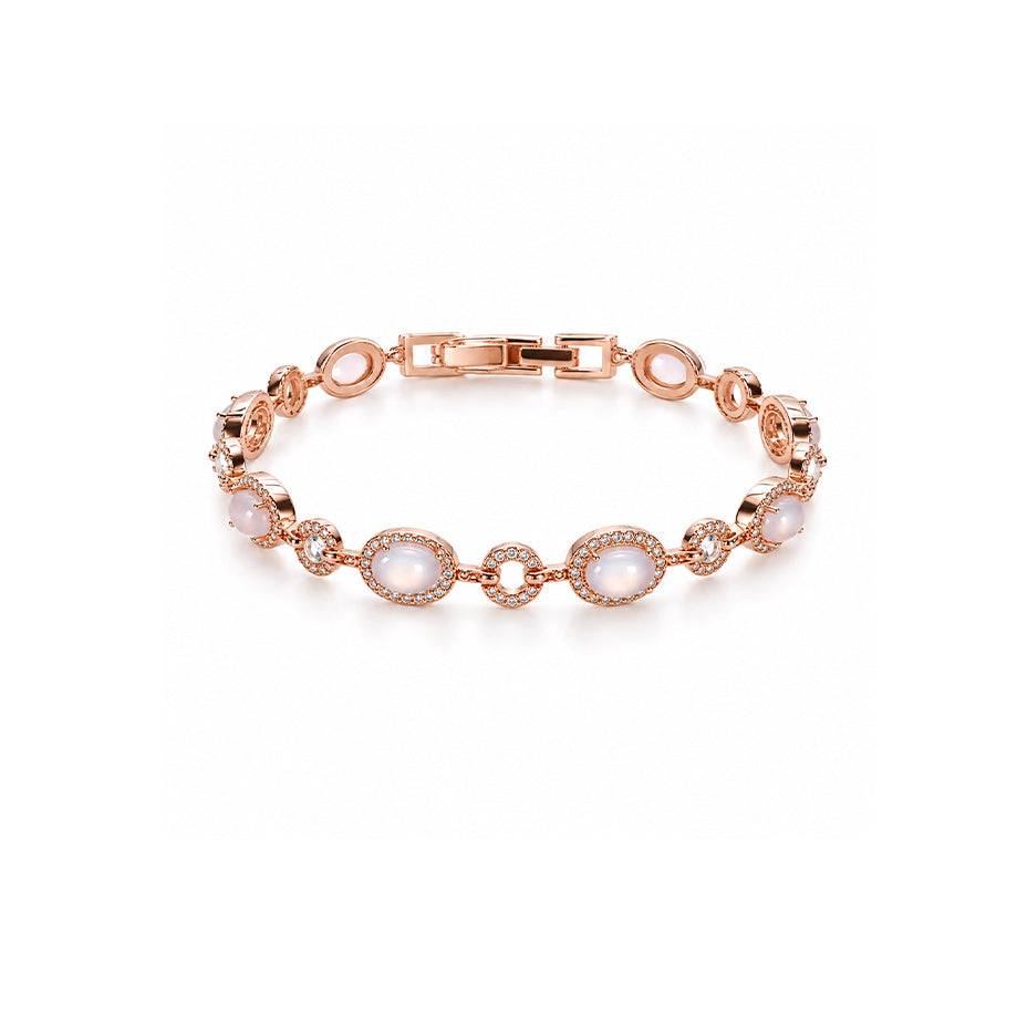 Rose gold-toned cz bracelet with oval milky moonstone-like cabochons, framed by rows of sparkling clear stones.