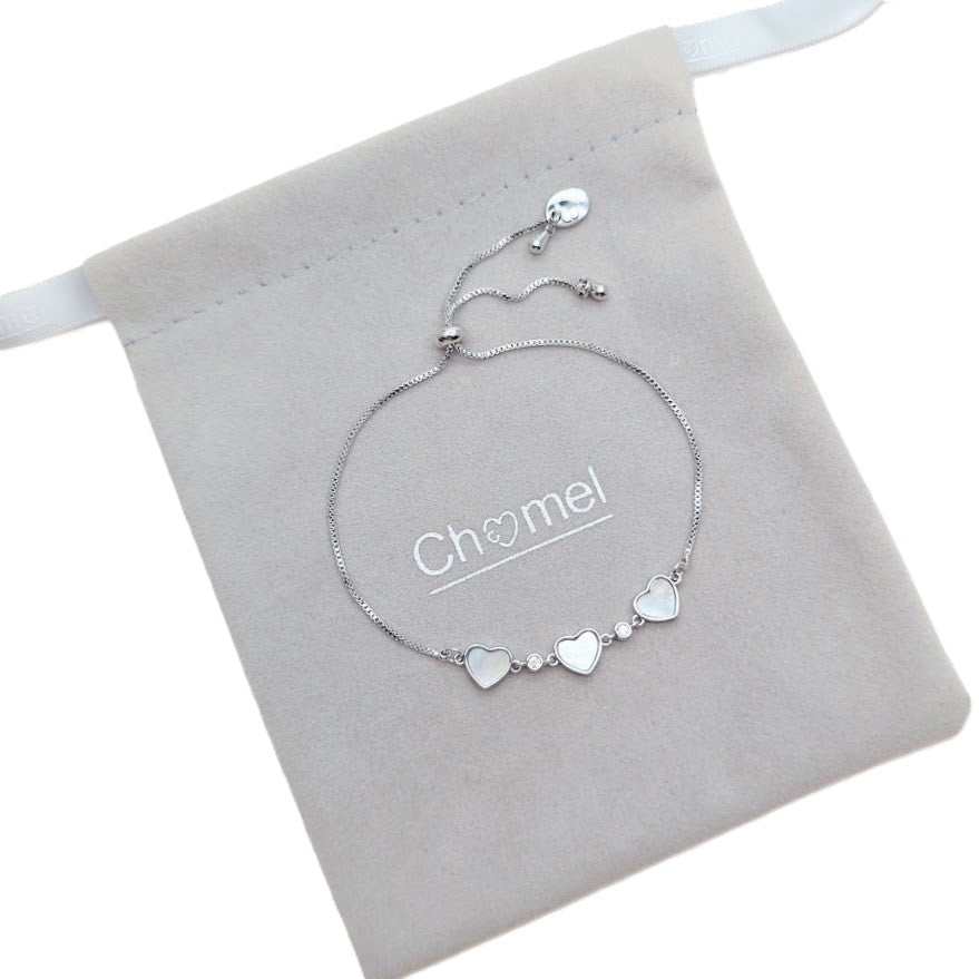 Dainty bracelet with three white heart charms and sparkling clear stones on a fine silver-tone adjustable chain