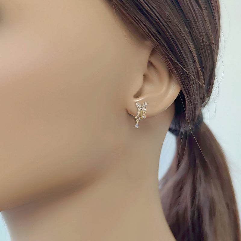 Gold-plated butterfly cubic zirconia clip-on earrings with dangling butterfly and teardrop solitaire design