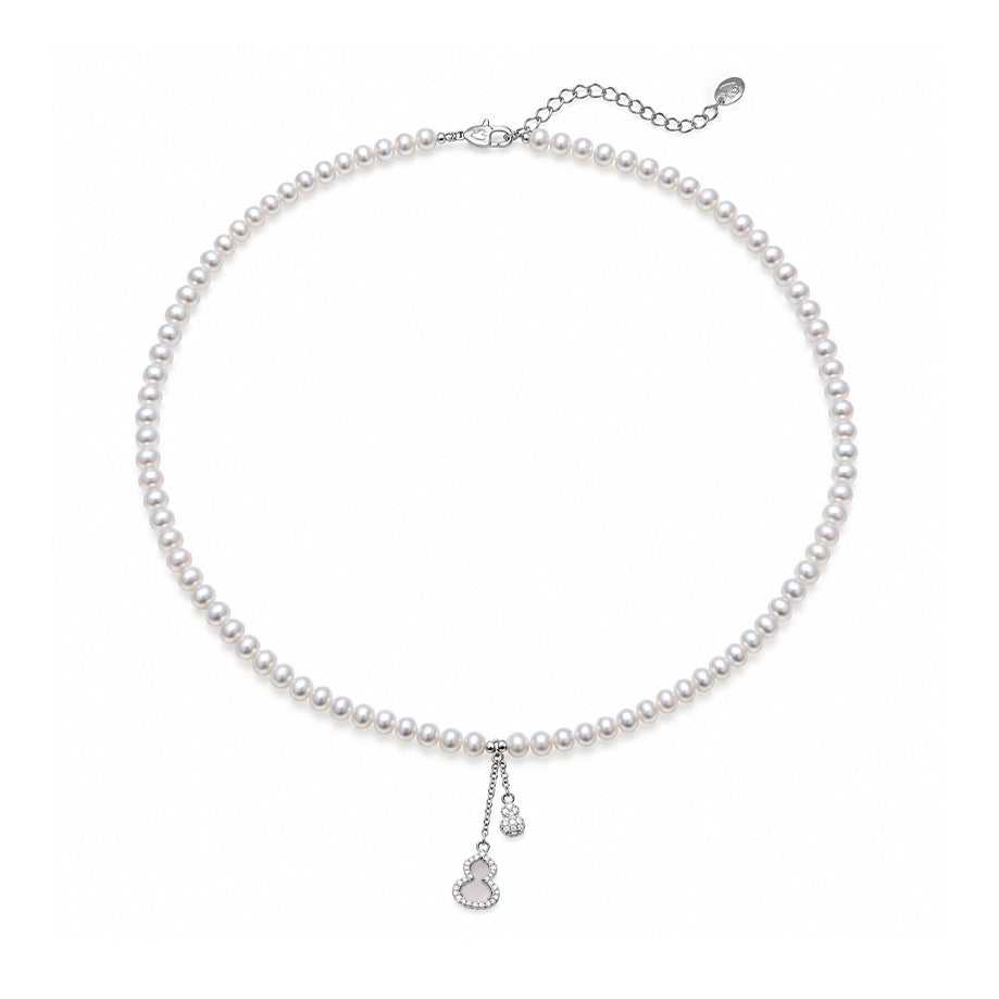 Freshwater Pearl necklace with small lustrous white pearls, silver-tone clasp and two delicate dangling charms.