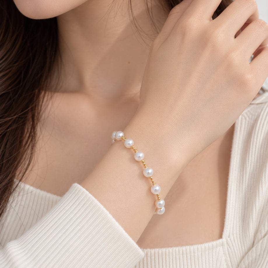 Freshwater Pearl Bracelet with lustrous white round pearls and small gold-tone spacer beads on a delicate strand