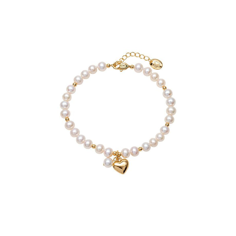 Freshwater Pearl Bracelet with lustrous white pearls, small gold beads, and a polished gold heart charm.
