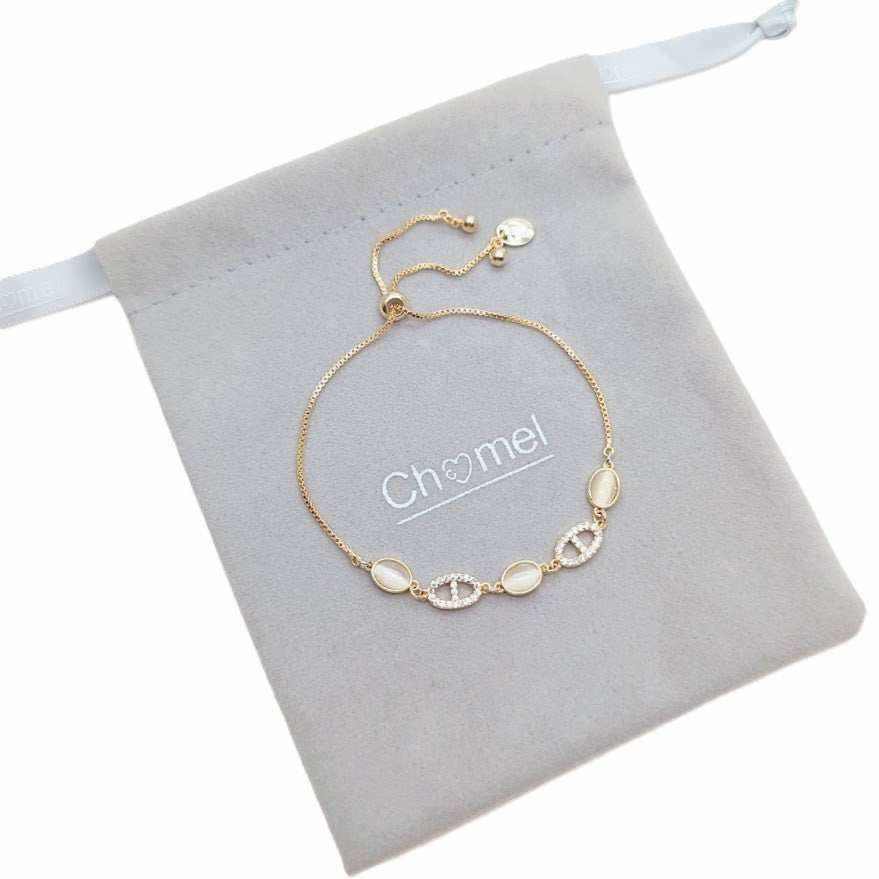 Gold bracelet with a fine gold-tone chain, oval pale stones and sparkling oval accents, featuring an adjustable slider clasp