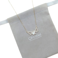 gold pendant necklace with a fine gold chain and three linked heart-shaped pendants, two outlined with clear stones