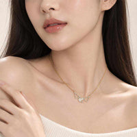 Gold pendant necklace with a delicate chain and three pale moonstone-look hulu shapes accented by sparkling stones