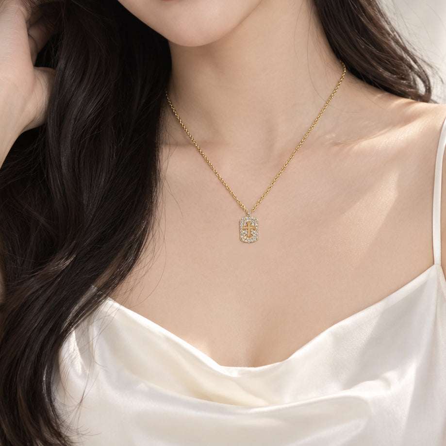 Gold-plated cubic zirconia cross pendant necklace featuring a delicate chain, perfect for layering with an Interlocking Ring style.
