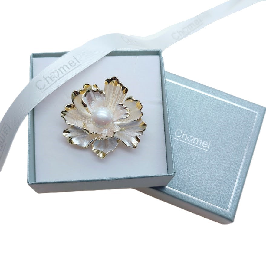 White enamel flower brooch with gold-plated edges and simulated freshwater pearl center