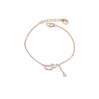 A delicate rose gold chain bracelet featuring a central double-heart motif, one heart paved with clear crystals and the other solid rose gold, with a small dangling crystal accent and adjustable lobster clasp.