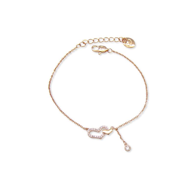 A delicate rose gold chain bracelet featuring a central double-heart motif, one heart paved with clear crystals and the other solid rose gold, with a small dangling crystal accent and adjustable lobster clasp.