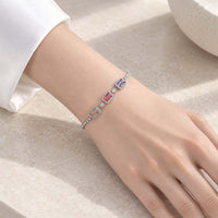 Cubic zirconia slider bracelet in silver-tone metal, with three colourful rectangular stones bordered by sparkling clear stones.