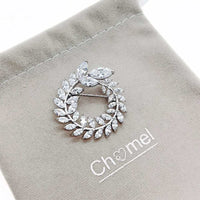 Leaf cubic zirconia brooch rhodium plated with rice shaped stones on beige pouch