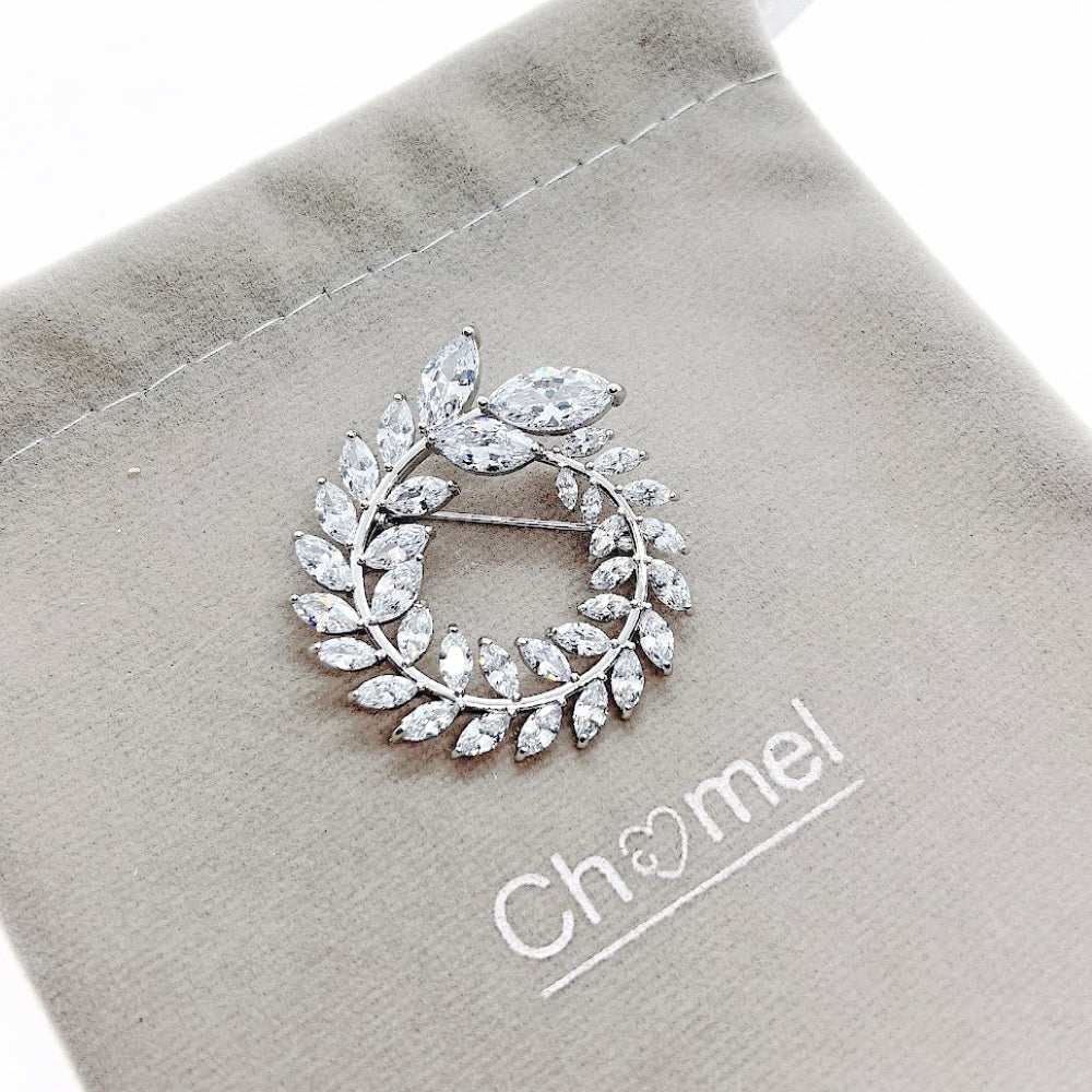 Leaf cubic zirconia brooch rhodium plated with rice shaped stones on beige pouch