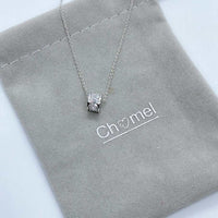 Cubic zirconia tunnel pendant necklace with rhodium plating on adjustable chain displayed on grey pouch