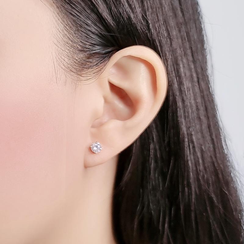 Close-up of ear wearing 4mm cubic zirconia solitaire stud earring with rhodium plated 4-claw setting