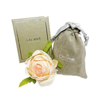 Leaf cubic zirconia brooch with rice-shaped stones, rhodium plated, 3.8 cm round, displayed with Chomel packaging and a peach rose.
