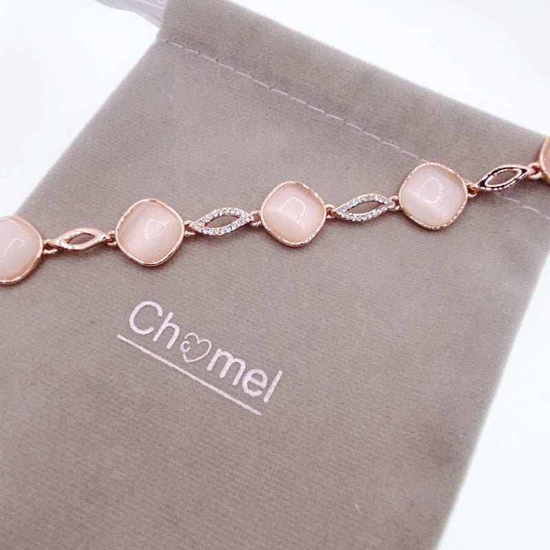 Rose gold-tone bracelet with pale pink round stones linked by sparkling crystal-set accents and polished oval links.