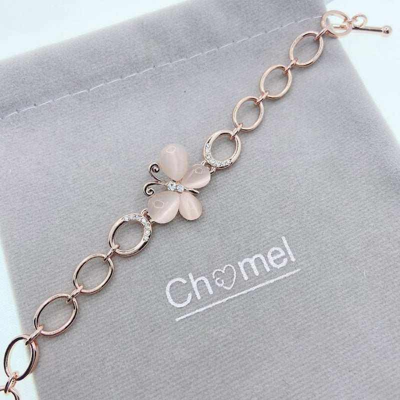Butterfly bracelet with rose gold-tone oval links, a pale pink translucent butterfly charm, and sparkling crystal accents